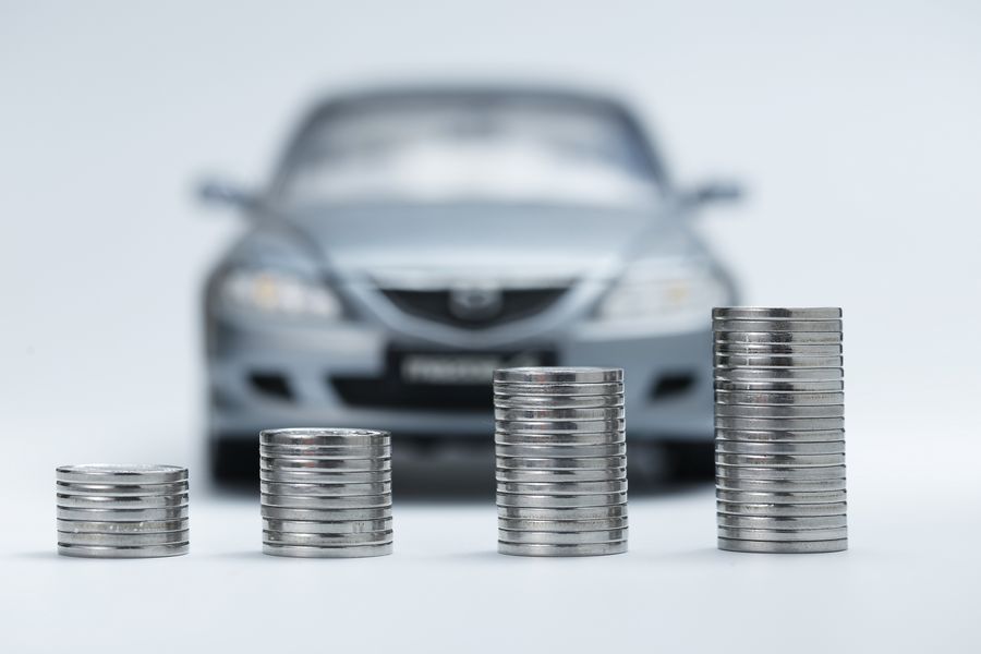 Vorteile Flottenmanagement Bild eines Geldstapels mit einem Auto im Hintergrund